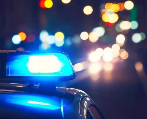 Closeup of emergency lighting on police car while driving on busy street