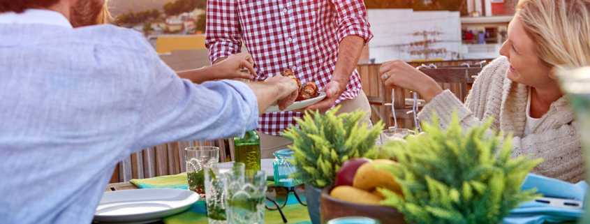 A Labor Day party host feeds guests at a cookout.