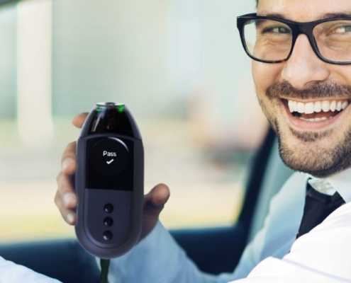 Man with glass holding an Ignition Interlock