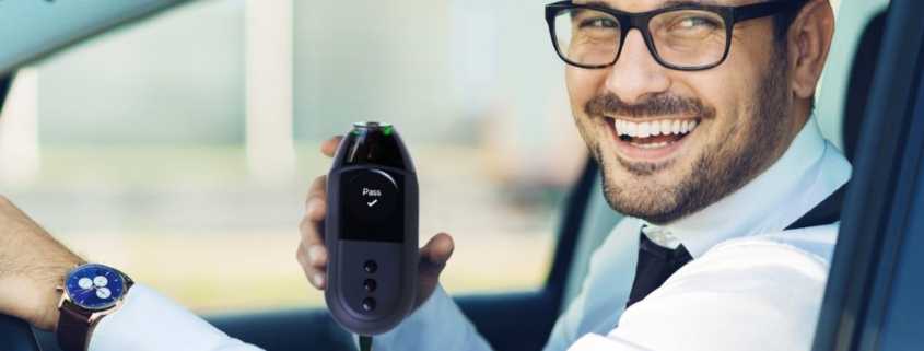 Man with glass holding an Ignition Interlock